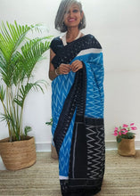 Load image into Gallery viewer, Chanchal, beautiful Ikat cotton sari, blue color with white chevron patterns, black border with motifs, black pallu chevron pattern, office wear, handwoven, casual wear.